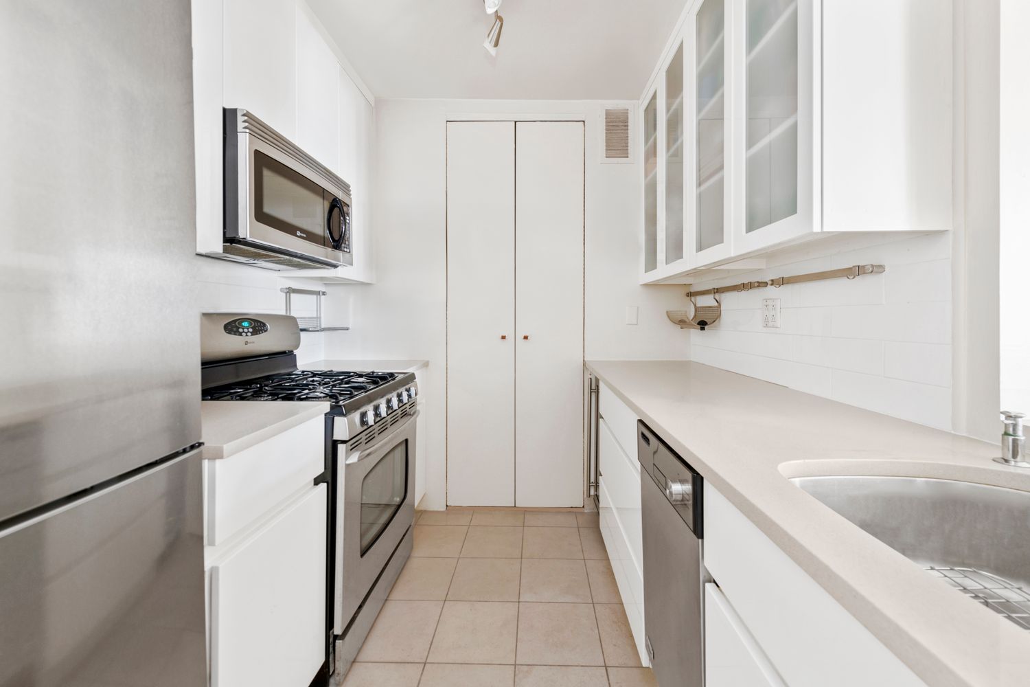 350 West 50th Street, Unit 15F Manhattan, NY 10019 - Photo 5 of 8 a kitchen with stainless steel appliances granite countertop a sink stove and refrigerator