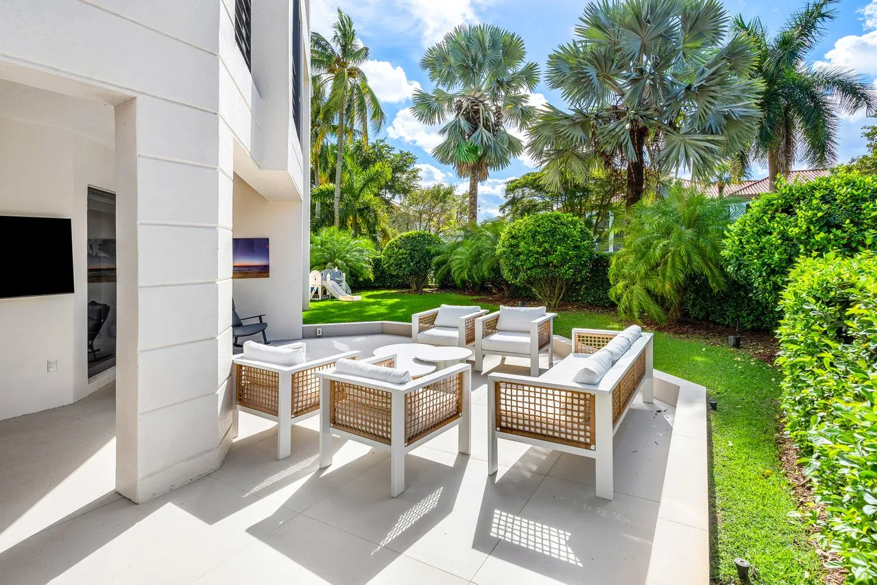 a view of a patio with couches table and chairs with wooden floor and fence