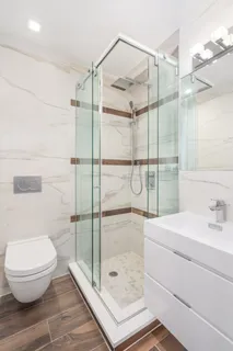 a bathroom with a shower a toilet and a sink