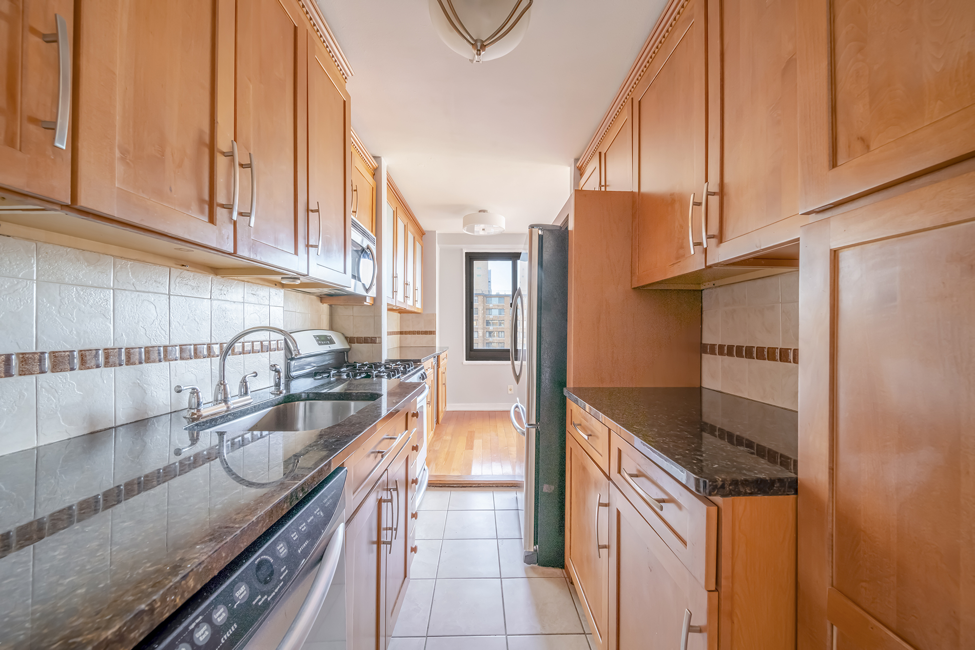 195 Willoughby Avenue, Unit 1518 Brooklyn, NY 11205 - Photo 5 of 7 a kitchen with stainless steel appliances granite countertop a sink a stove and a refrigerator