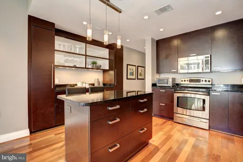 a kitchen with stainless steel appliances granite countertop a stove a sink and a refrigerator