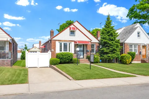 a front view of a house with a yard and trees