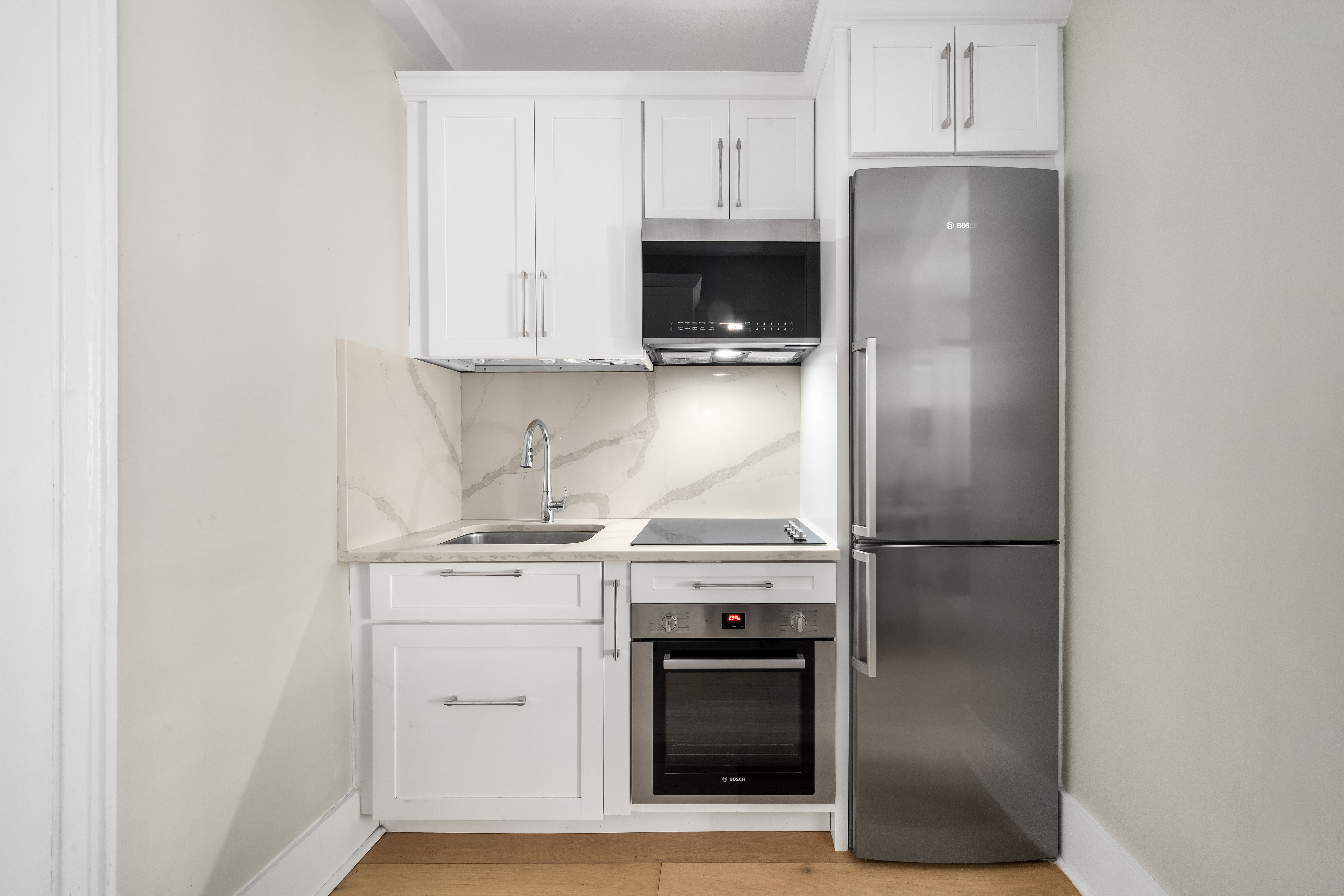 24 5th Avenue, Unit 1212 Manhattan, NY 10011 - Photo 2 of 9 a kitchen with a stove and a refrigerator