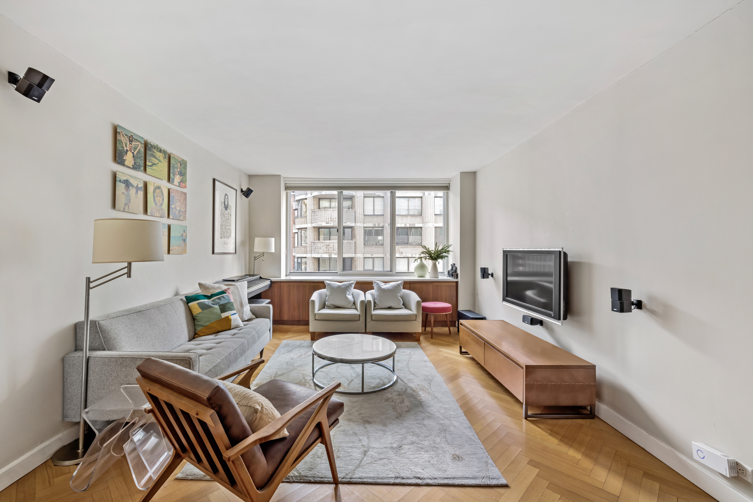 61 West 62nd Street, Unit 23G Manhattan, NY 10023 - Photo 1 of 9 a living room with furniture and a flat screen tv