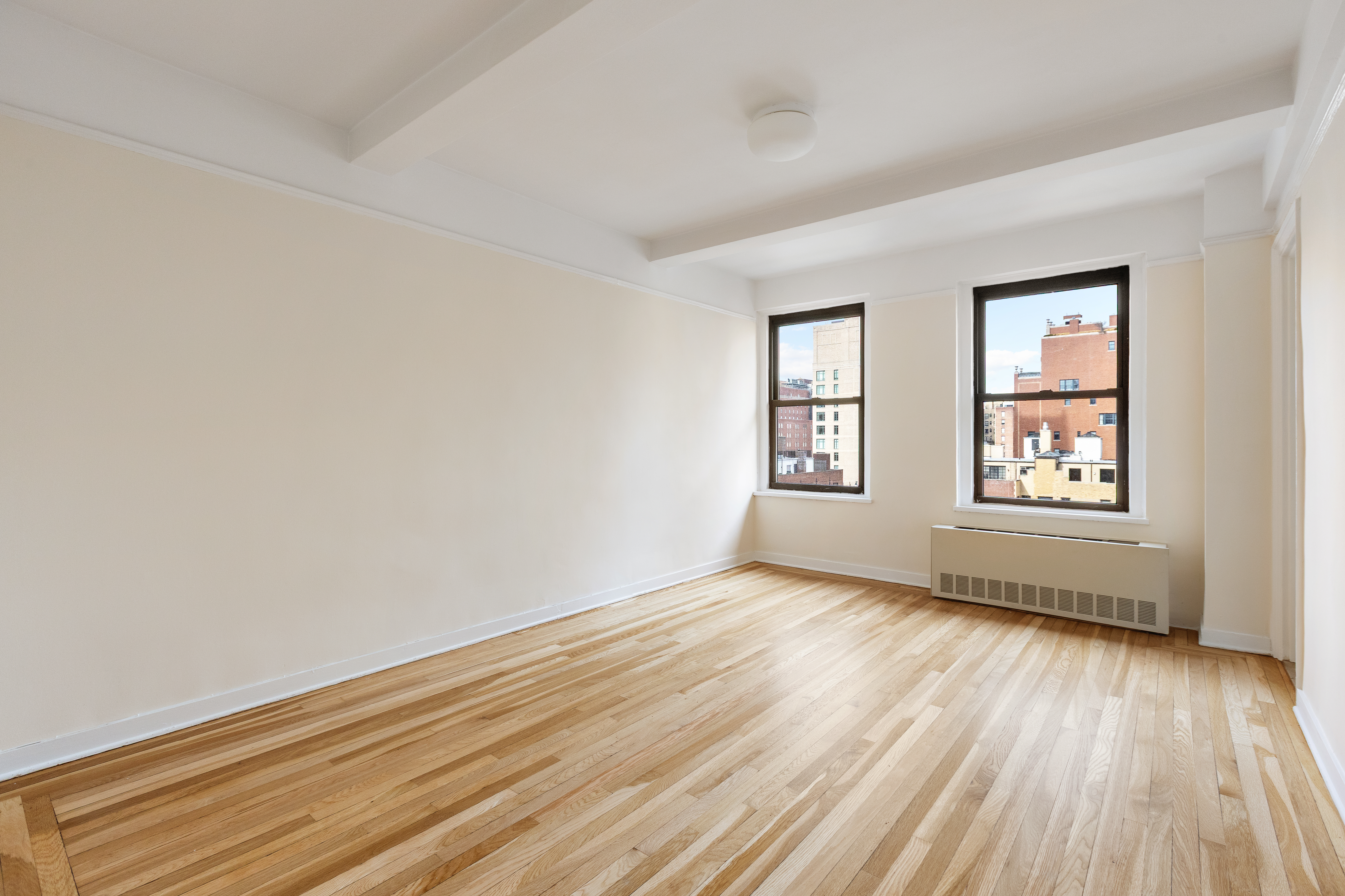 205 East 78th Street, Unit 14C Manhattan, NY 10075 - Photo 8 of 12 an empty room with wooden floor and windows