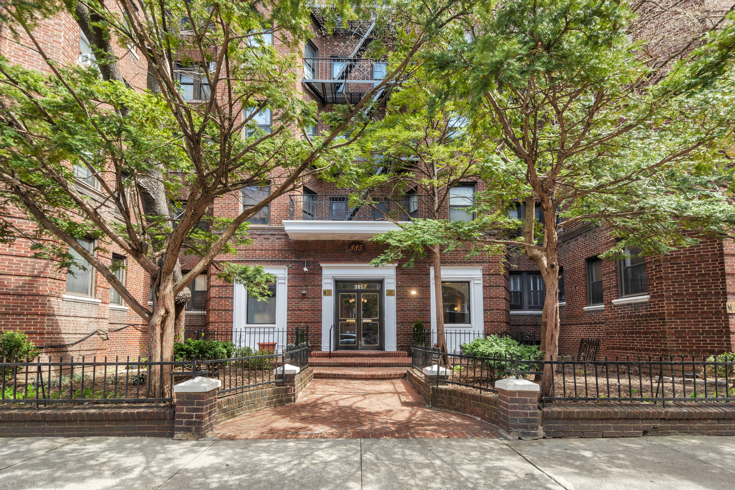 385 Argyle Road, Unit 1B Brooklyn, NY 11218 - Photo 10 of 11 a view of a brick house with large windows and a large tree