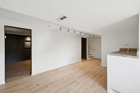 a view of a storage & utility room with closet wooden floor and windows