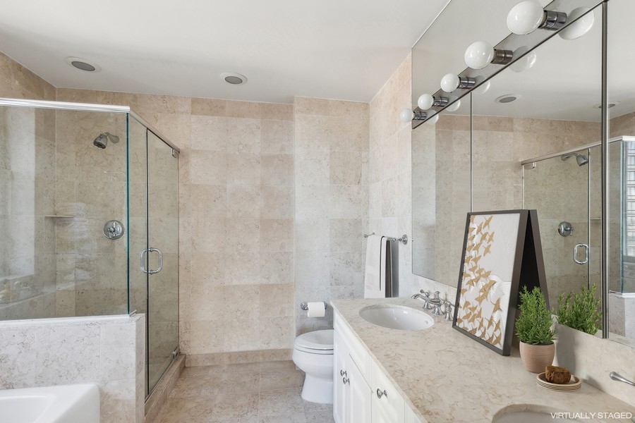 2 Columbus Avenue, Unit 23A Manhattan, NY 10019 - Photo 5 of 10 a bathroom with a granite countertop sink a toilet and shower