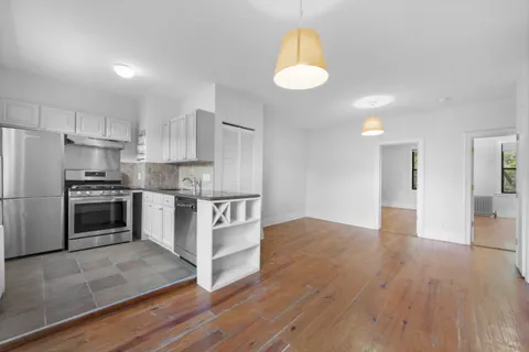 a kitchen with granite countertop a stove a sink and a refrigerator