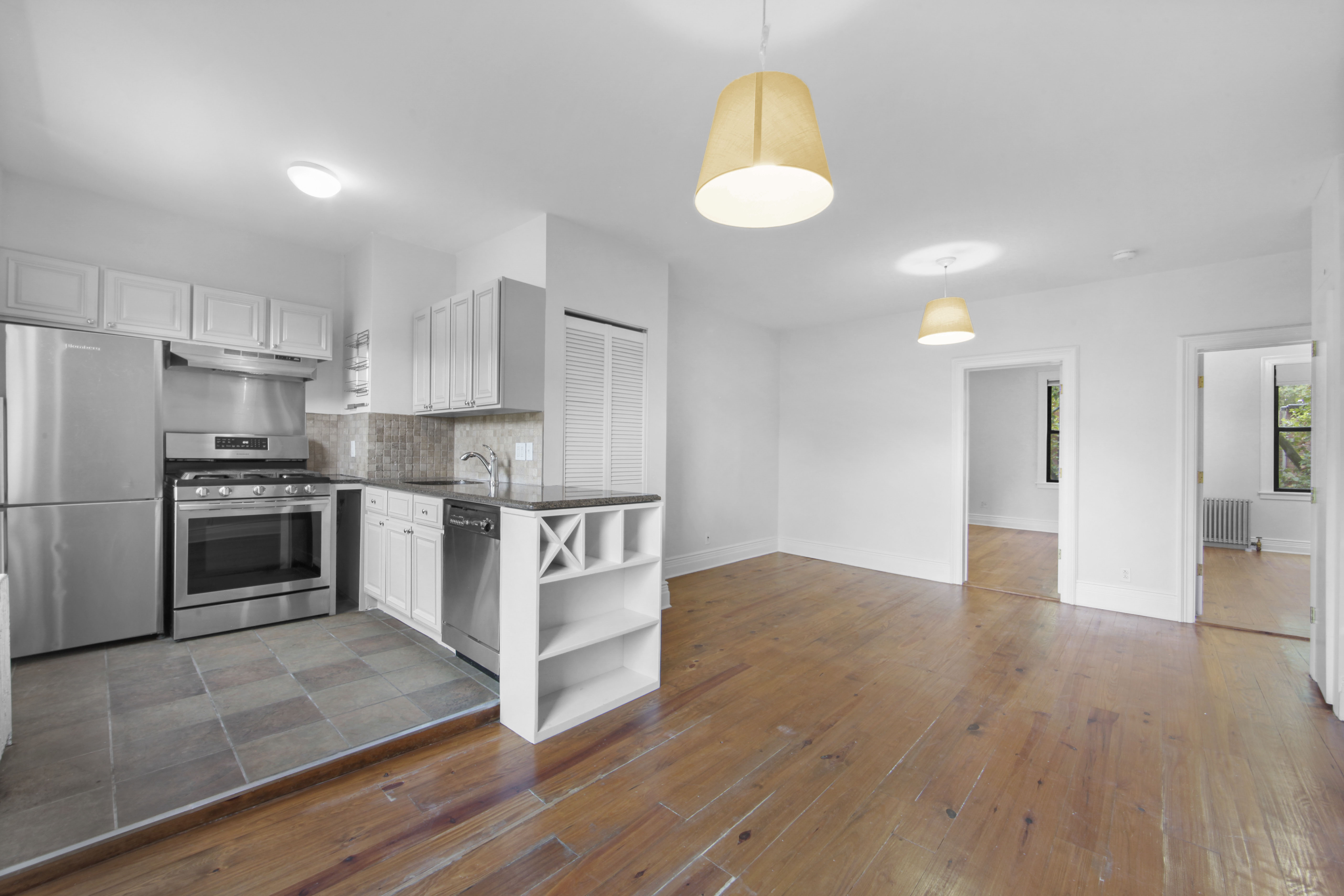 a kitchen with granite countertop a stove a sink and a refrigerator