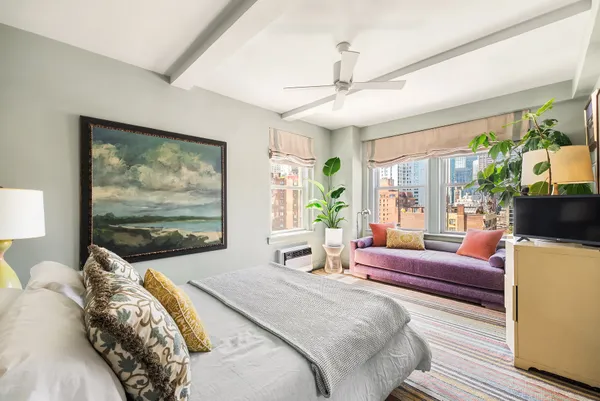 a bedroom with furniture and a large window