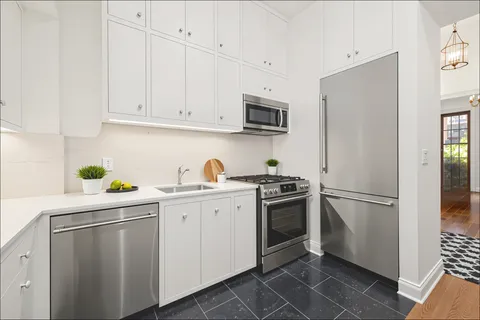 a kitchen with cabinets stainless steel appliances and a counter space