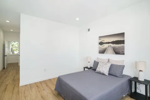 a bedroom with a bed and a painting on the wall