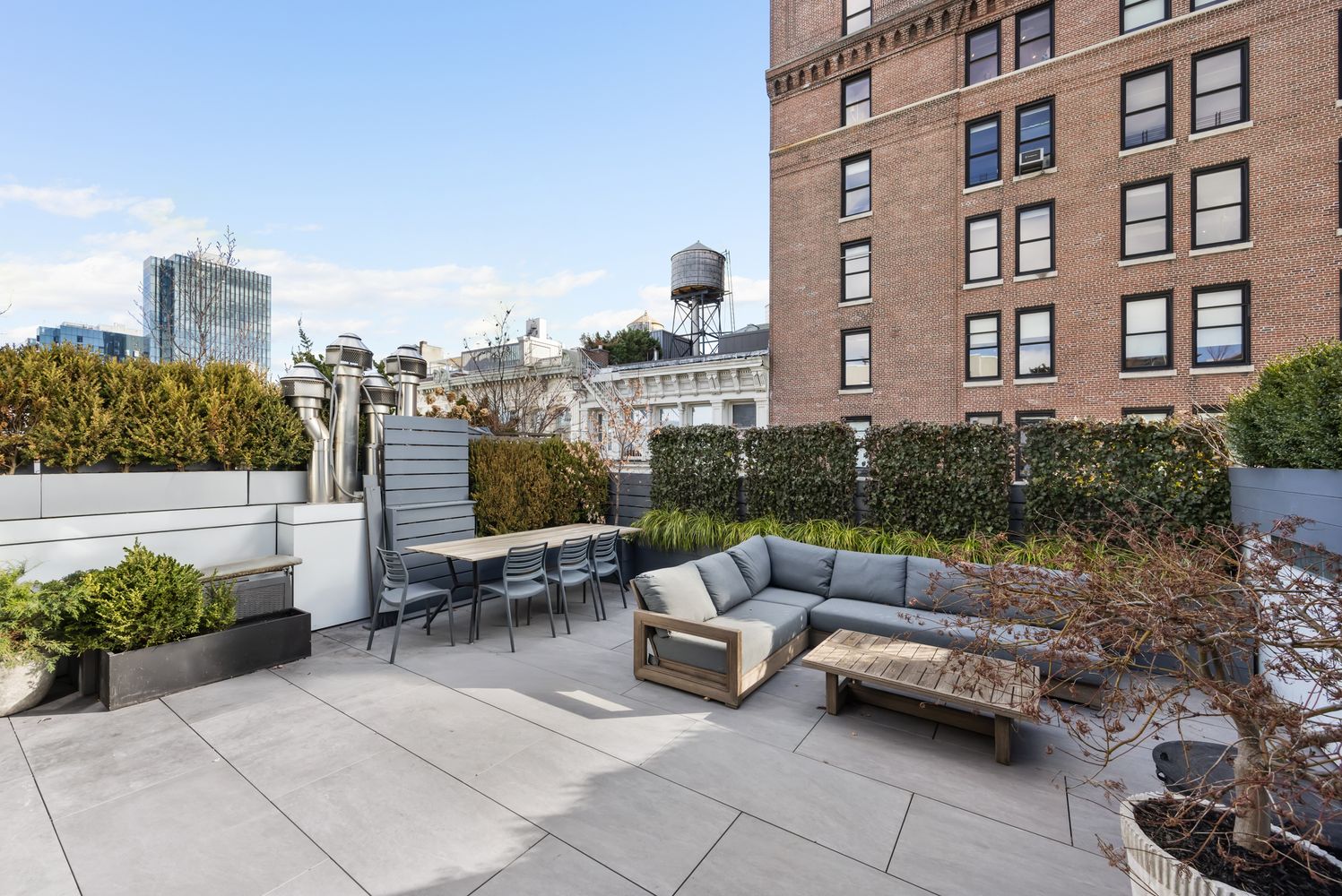 a roof deck with couch and potted plants