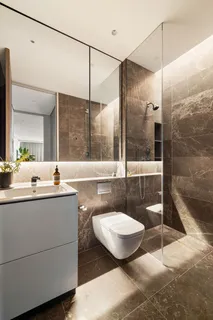 a bathroom with a sink a toilet a mirror and shower