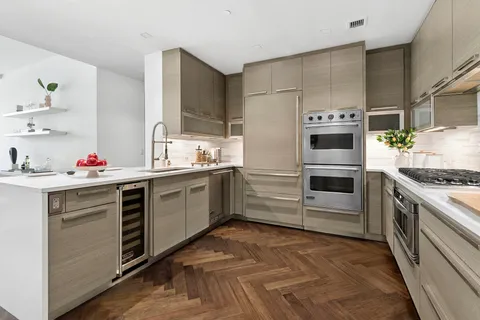a kitchen with stainless steel appliances a stove a sink and a refrigerator