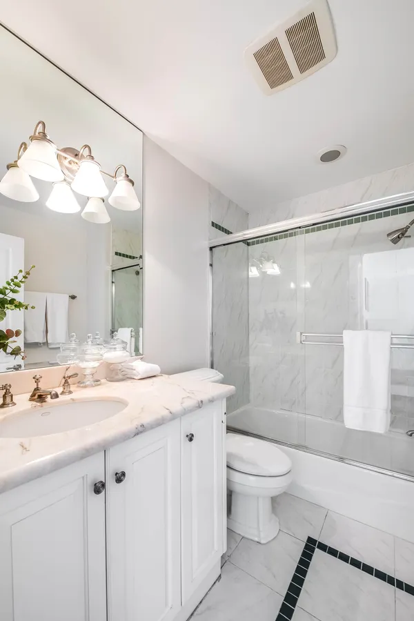 a bathroom with a sink vanity granite toilet and a mirror