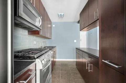 a kitchen with granite countertop a stove and a refrigerator