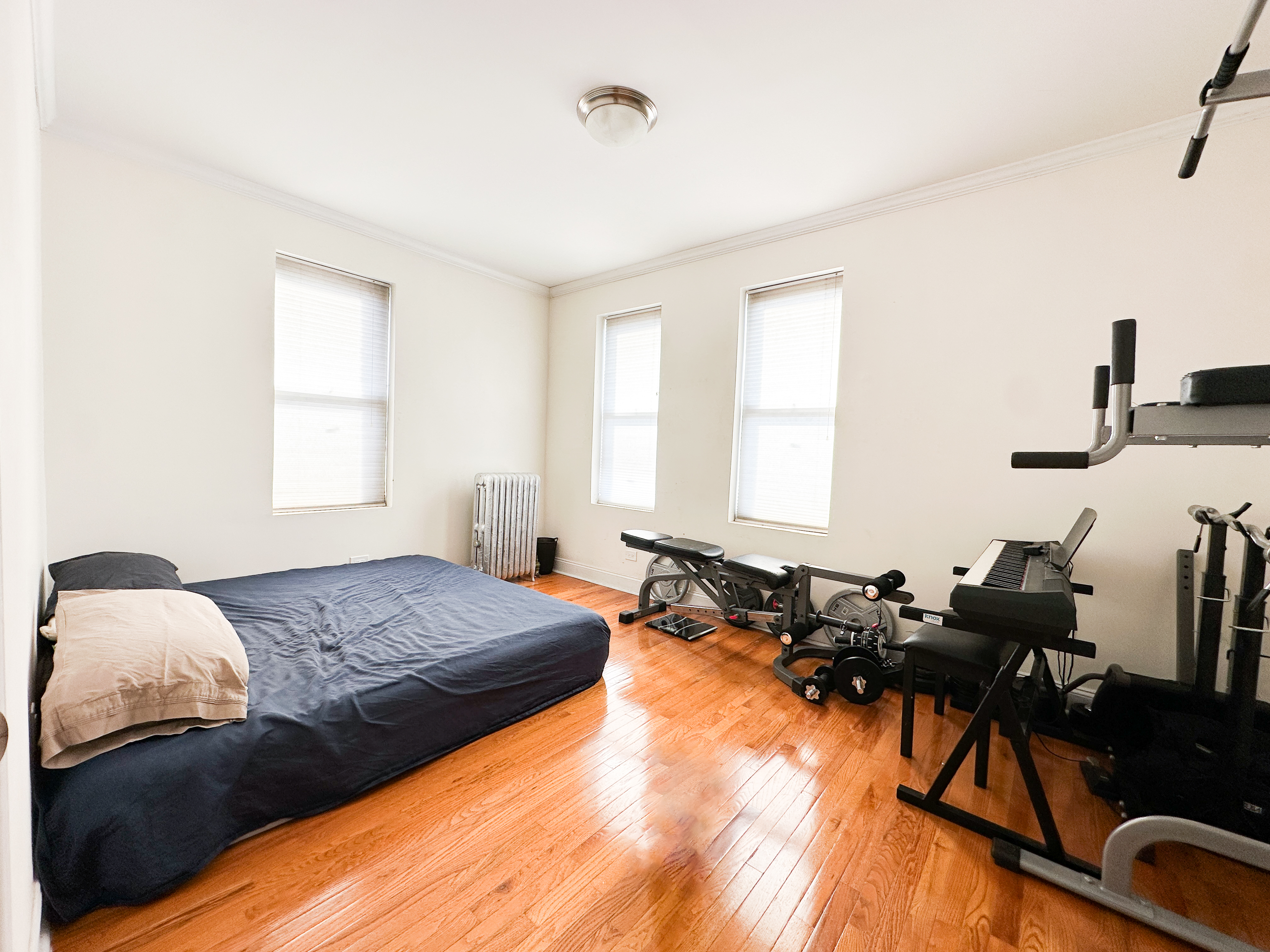 1506 Overing Street, Unit 1D Bronx, NY 10461 - Photo 4 of 10 a spacious bedroom with a bed a couch and dresser in it