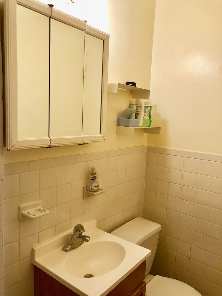 344 East 61st Street, Unit 7 Manhattan, NY 10065 - Photo 4 of 4 a bathroom with a sink a toilet and mirror