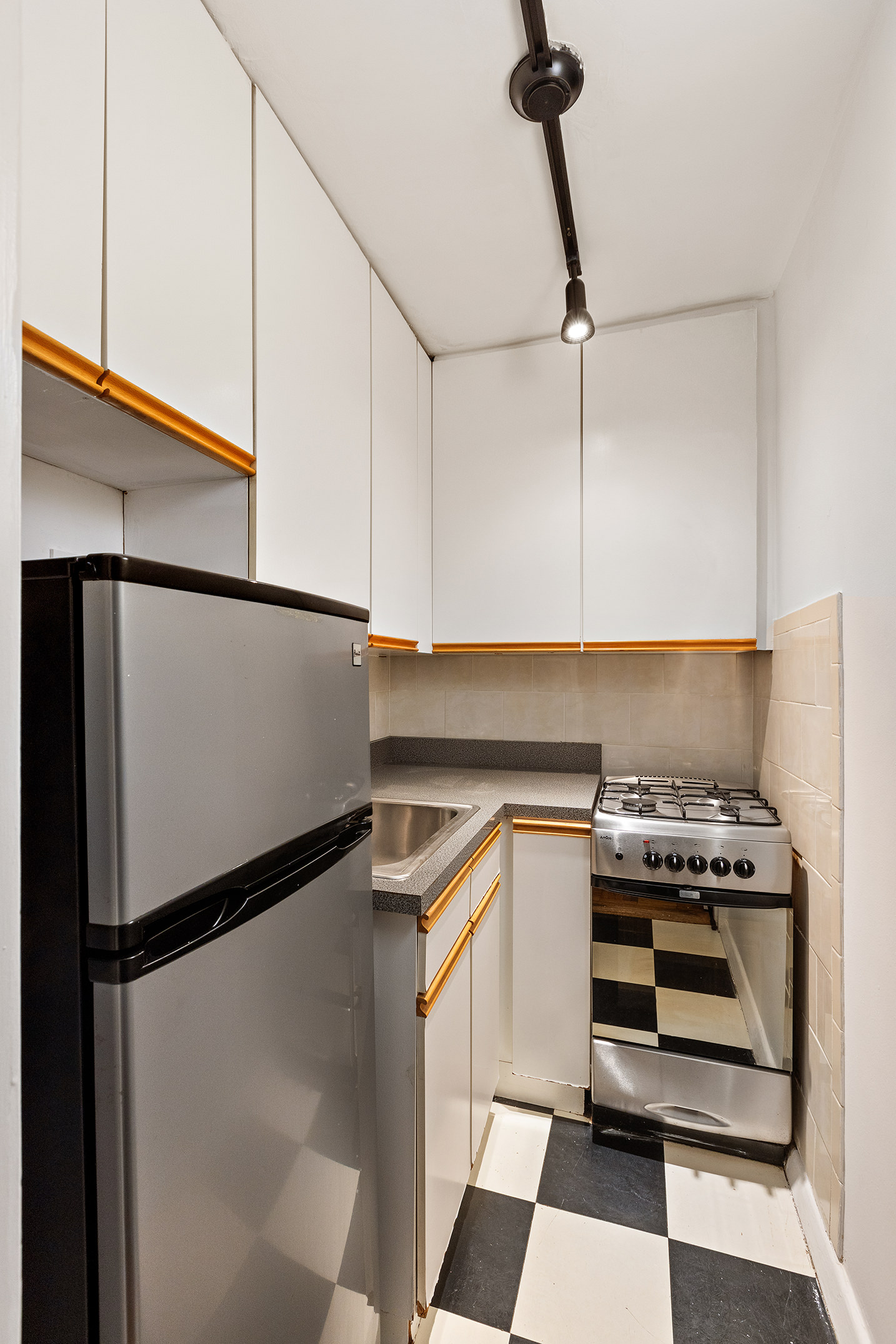 335 East 51st Street, Unit 3H Manhattan, NY 10022 - Photo 7 of 11 a kitchen with a refrigerator and a stove