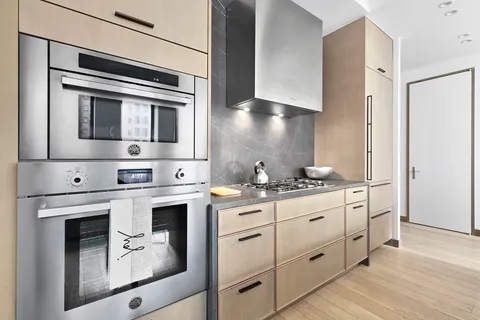 a kitchen with stainless steel appliances granite countertop a stove and white cabinets