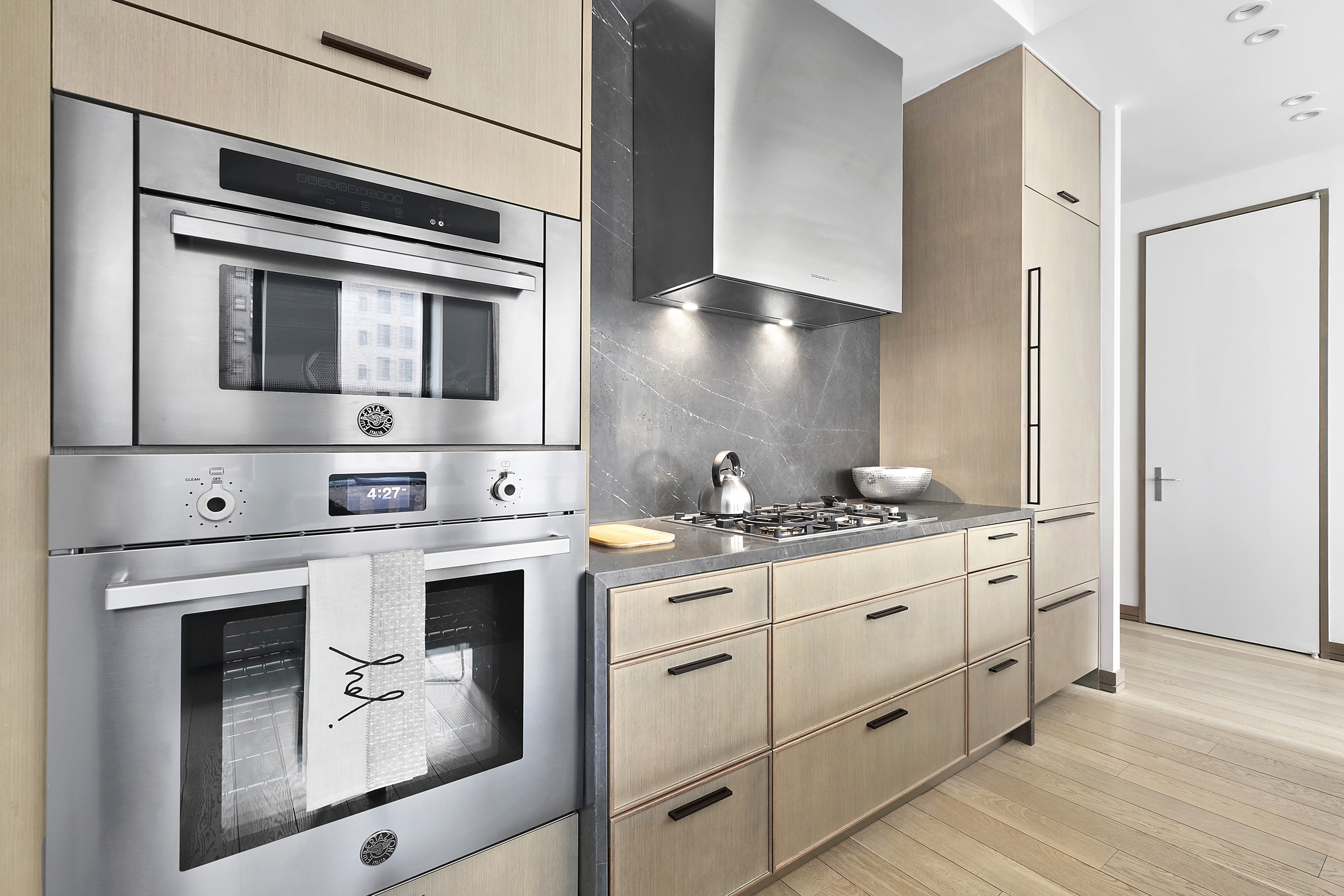 88 Lexington Avenue, Unit 802 Manhattan, NY 10016 - Photo 4 of 22 a kitchen with stainless steel appliances granite countertop a stove and white cabinets