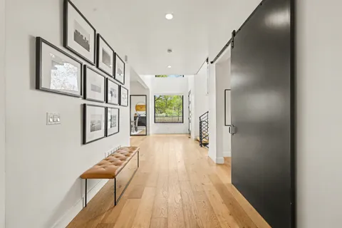 a view of a hallway with wooden floor and staircase