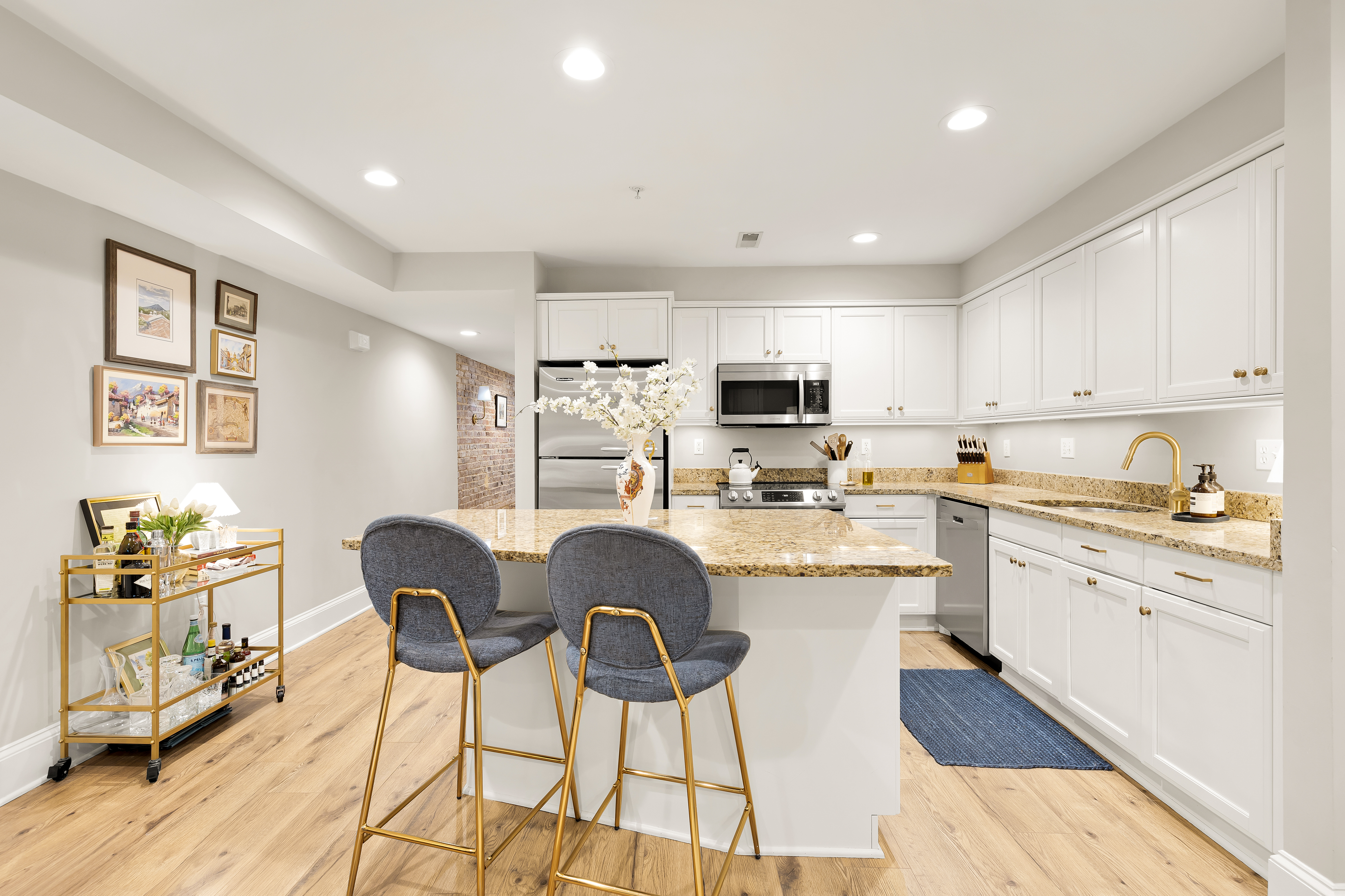 1354 Kenyon Street Northwest, Unit G Washington, DC 20010 - Photo 9 of 35 a kitchen with stainless steel appliances kitchen island granite countertop a dining table chairs refrigerator and sink