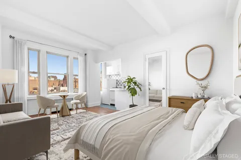 a bedroom with bed a table and chair