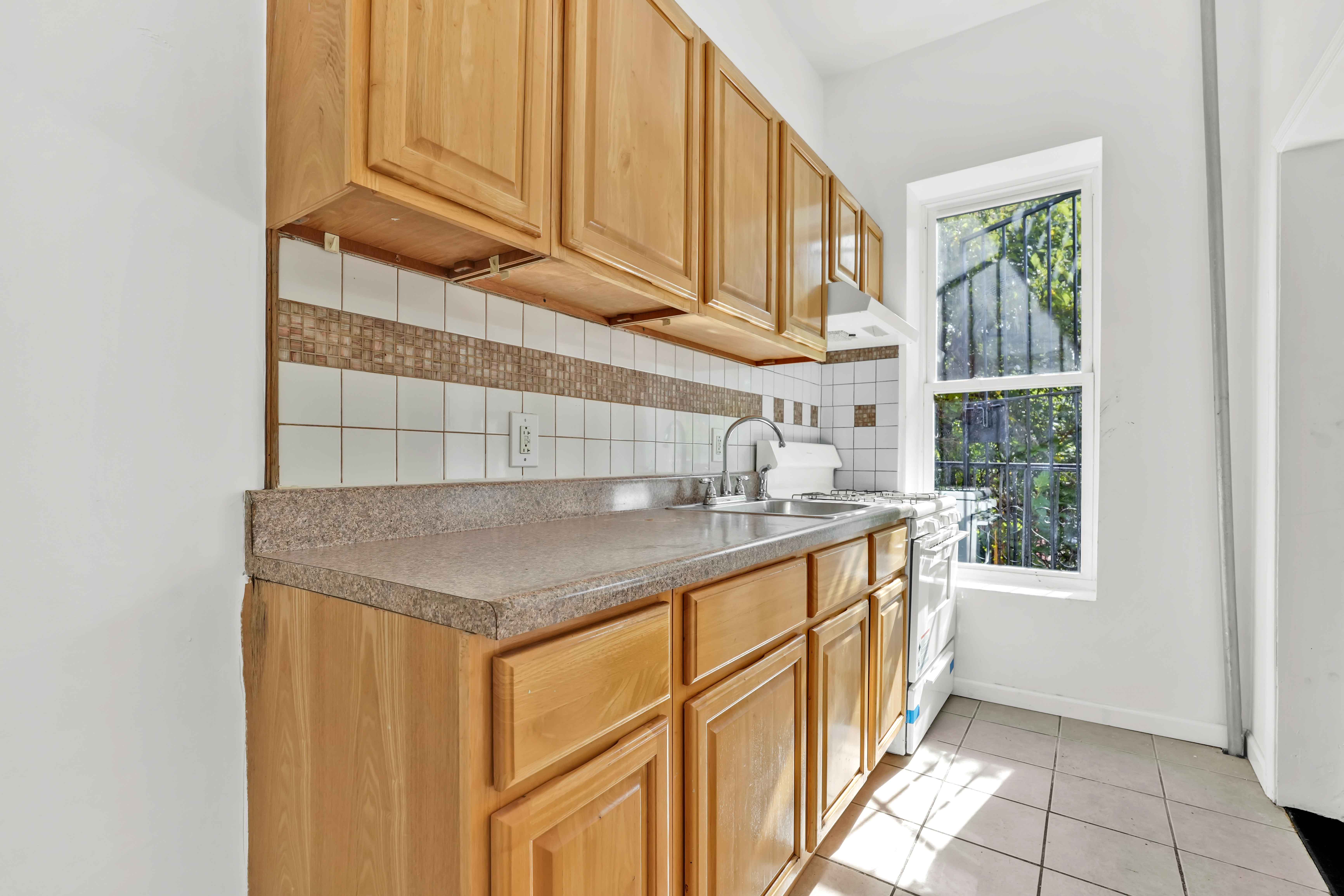 238 Vernon Avenue, Unit 2 Brooklyn, NY 11206 - Photo 12 of 21 a kitchen with stainless steel appliances granite countertop a sink and a window