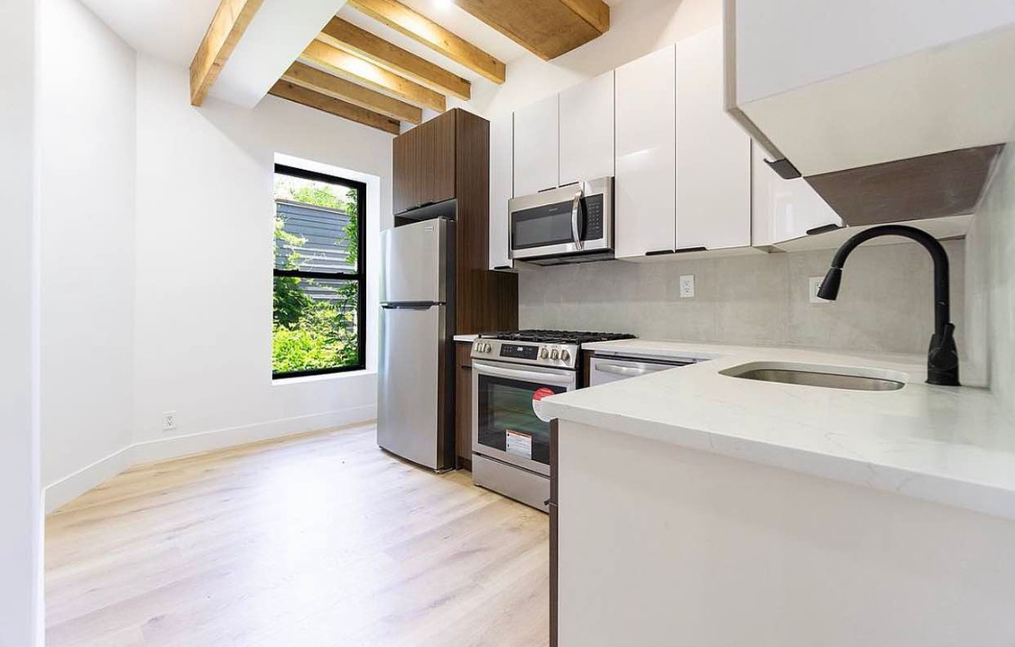 180 5th Avenue, Unit 3 Brooklyn, NY 11217 - Photo 3 of 13 a kitchen with stainless steel appliances granite countertop a sink a stove a microwave and view