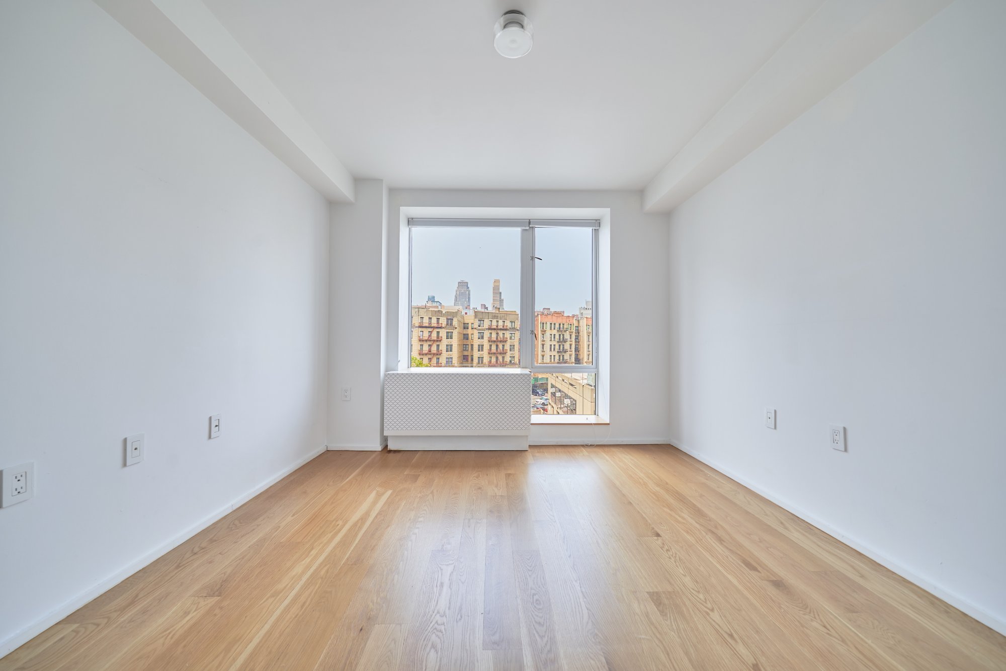 2280 Frederick Douglass Boulevard, Unit 5D Manhattan, NY 10027 - Photo 11 of 22 an empty room with wooden floor and windows