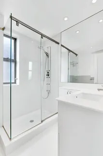 a bathroom with a shower sink and mirror