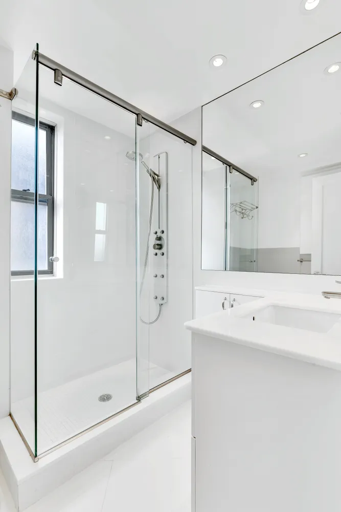 a bathroom with a shower sink and mirror