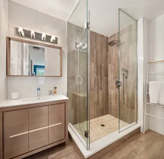 a bathroom with a shower sink and mirror