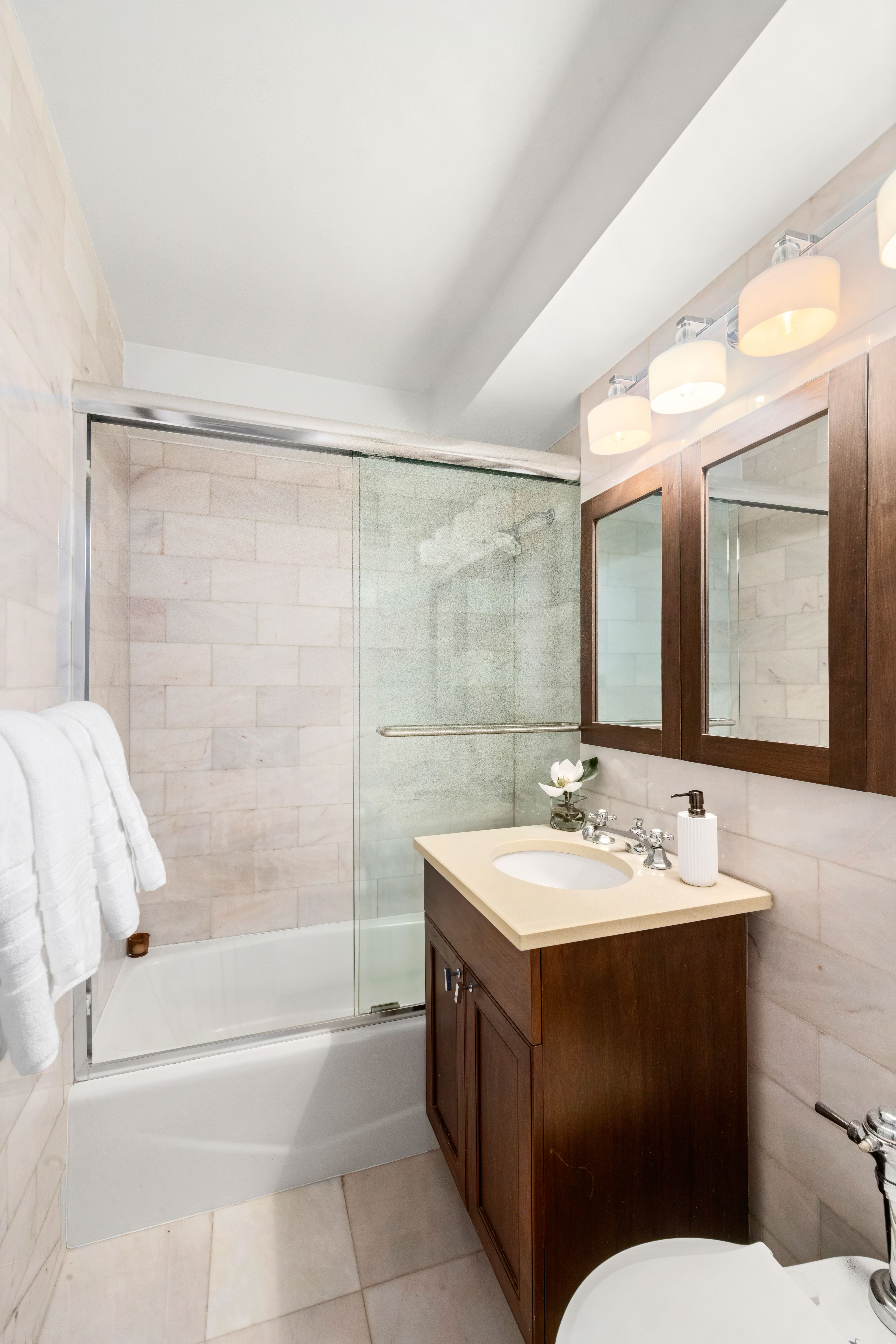 205 East 77th Street, Unit 3A Manhattan, NY 10075 - Photo 6 of 9 a bathroom with a sink and a mirror