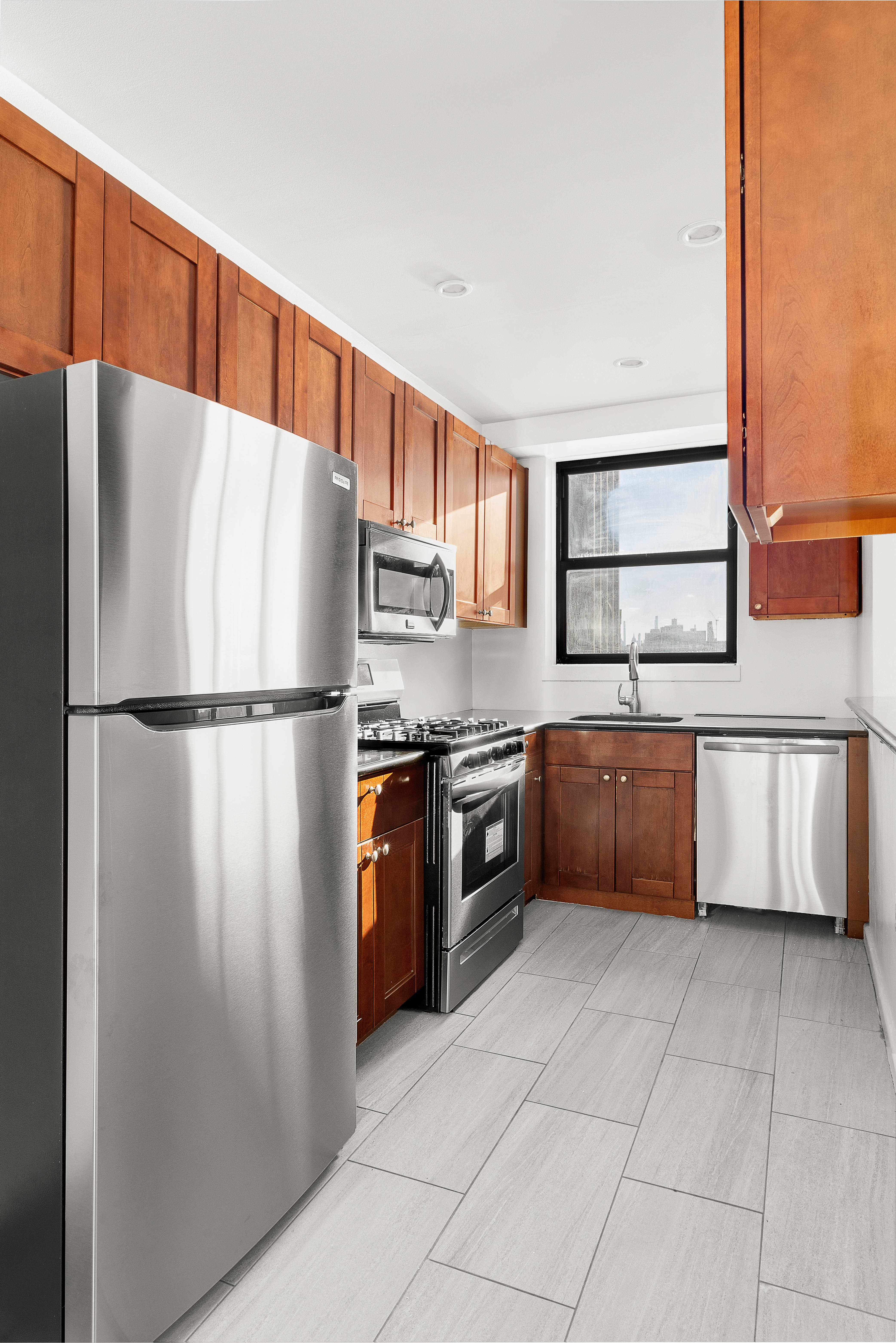 158-18 Riverside Drive West, Unit 4E50 Manhattan, NY 10032 - Photo 5 of 17 a kitchen with stainless steel appliances granite countertop a refrigerator sink and cabinets