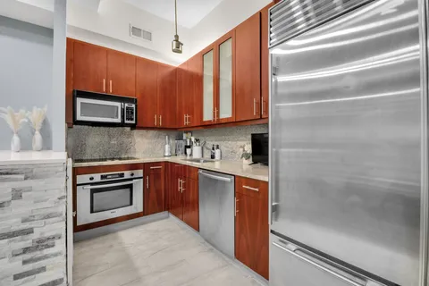 a kitchen with stainless steel appliances granite countertop a stove microwave and cabinets
