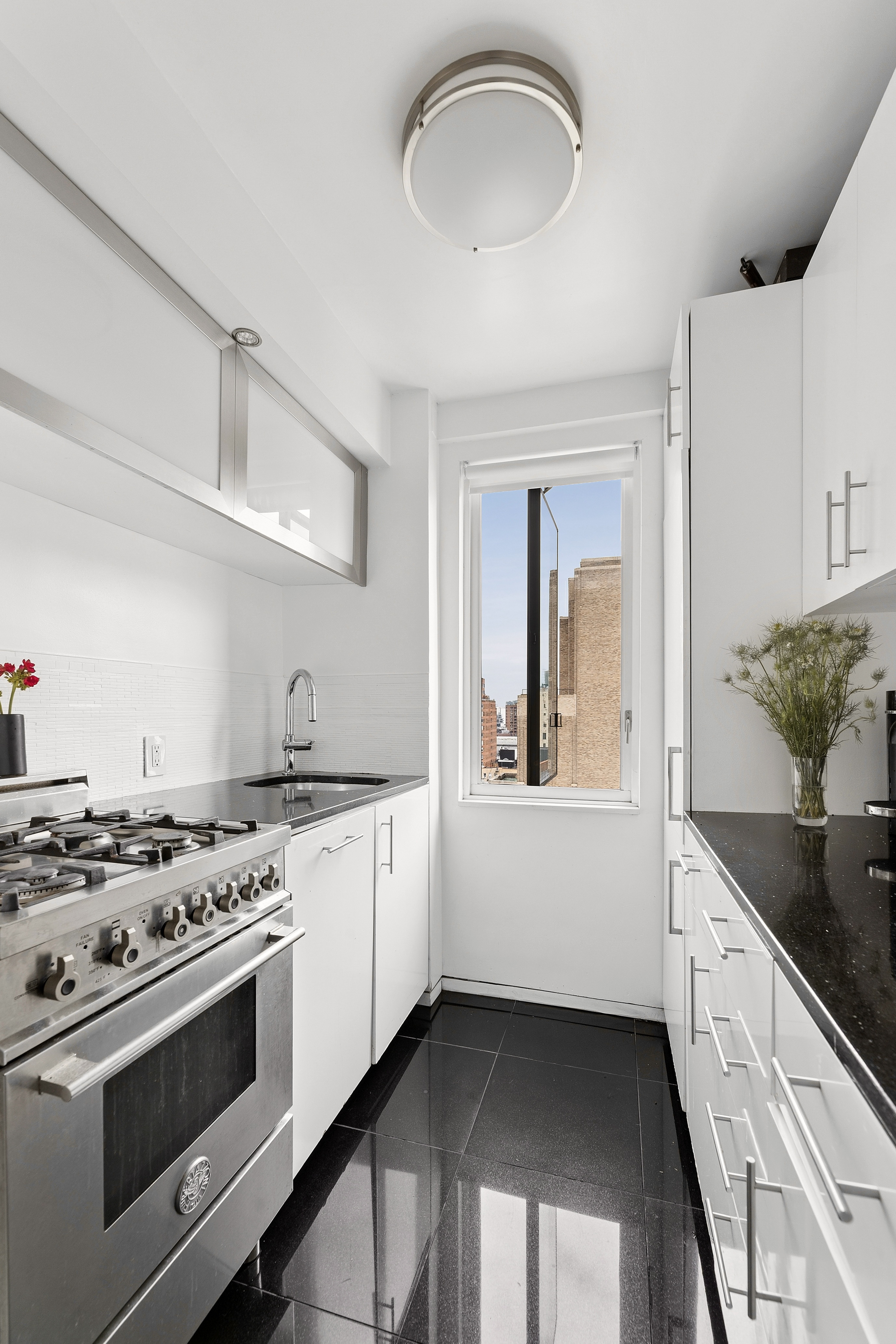 105 West 13th Street, Unit 16F Manhattan, NY 10011 - Photo 3 of 12 a kitchen with stainless steel appliances granite countertop a stove and a sink