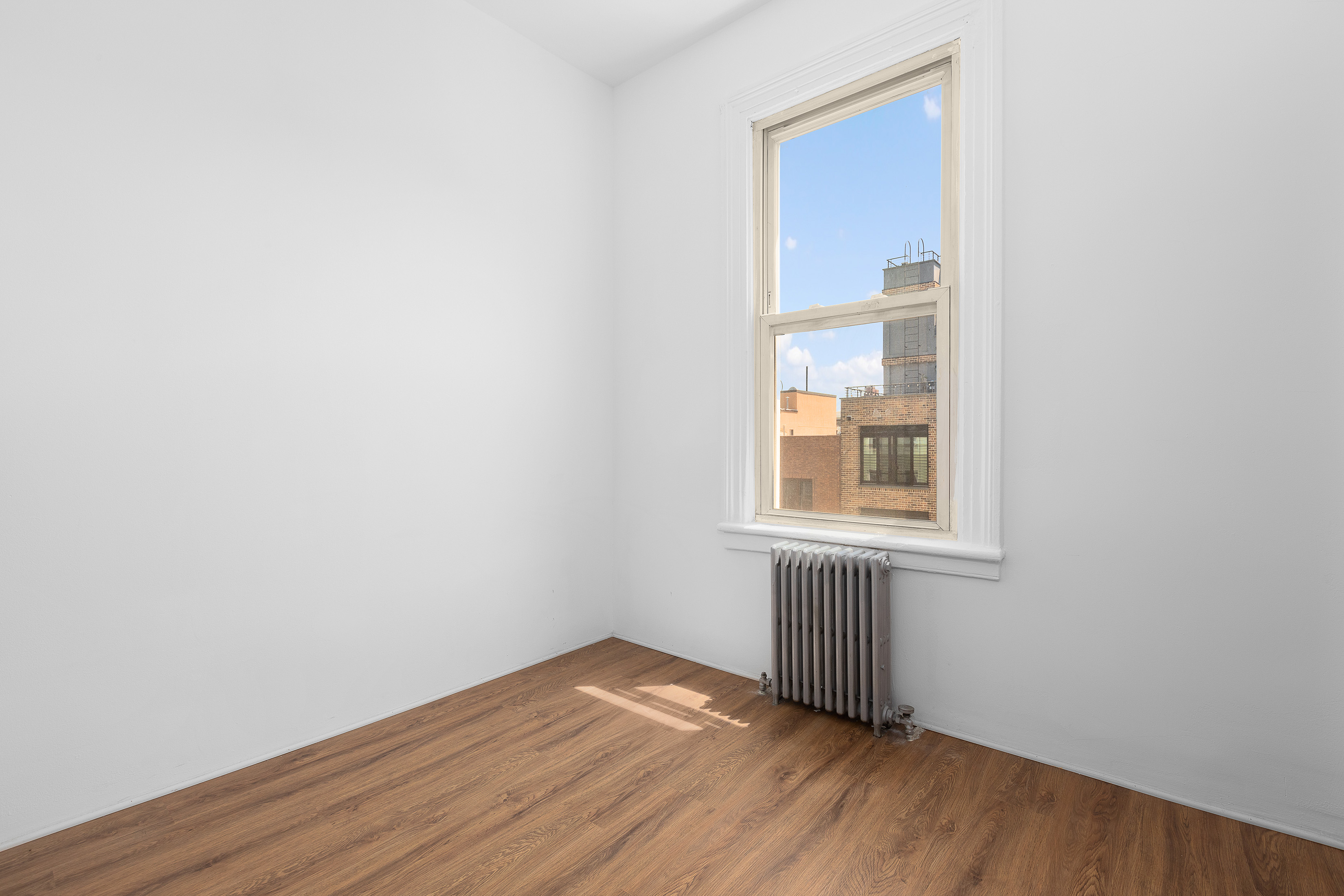 39 Broome Street Brooklyn, NY 11222 - Photo 12 of 16 a view of empty room with wooden floor and fan