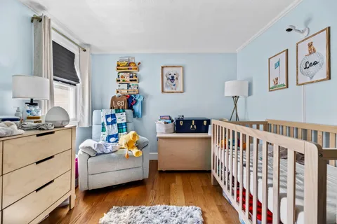 a living room with furniture and a baby crib
