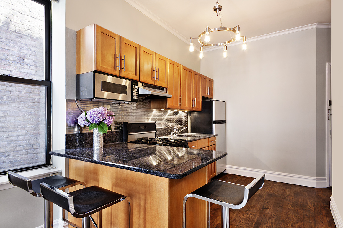 442 Amsterdam Avenue, Unit 4C Manhattan, NY 10024 - Photo 3 of 9 a kitchen with stainless steel appliances granite countertop a stove a refrigerator and a microwave