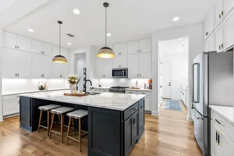 a kitchen with kitchen island a counter top space appliances and cabinets