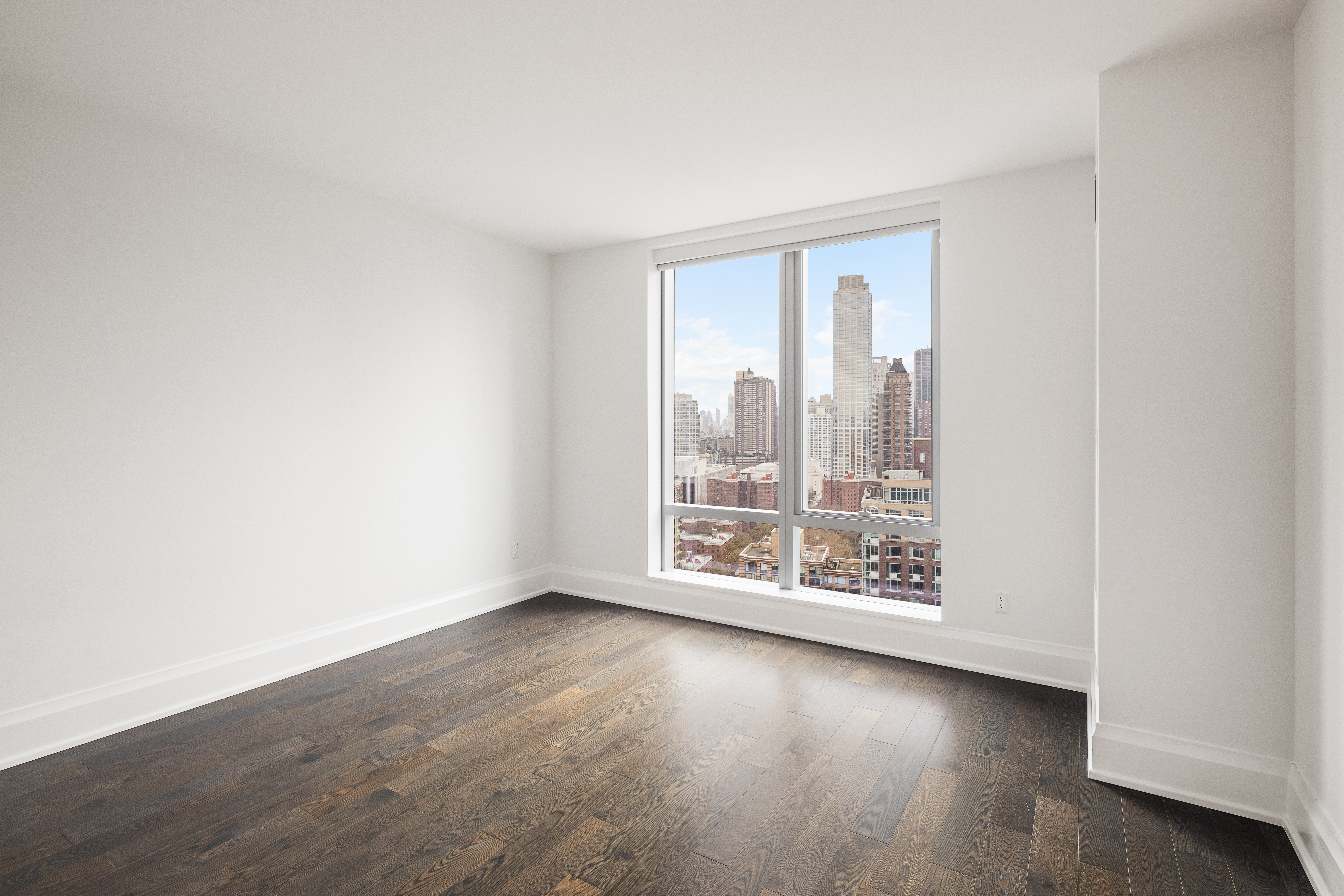 50 Riverside Boulevard, Unit 30B Manhattan, NY 10069 - Photo 12 of 14 an empty room with wooden floor and windows