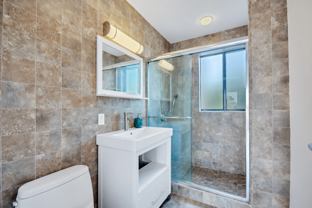 416 East 117th Street, Unit PH6 Manhattan, NY 10035 - Photo 15 of 18 a bathroom with a sink a toilet and shower