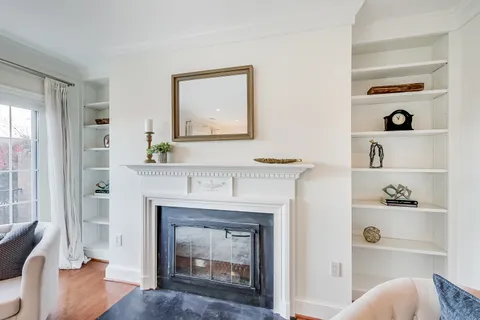 a living room with a fireplace cabinet and a window