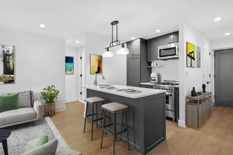 a kitchen with stainless steel appliances kitchen island a stove and a living room