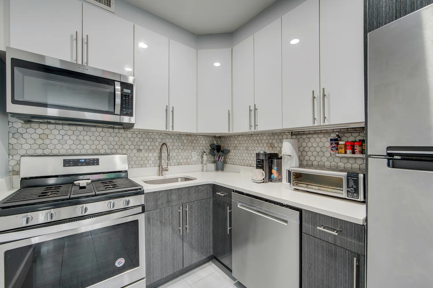 a kitchen with cabinets stainless steel appliances and sink