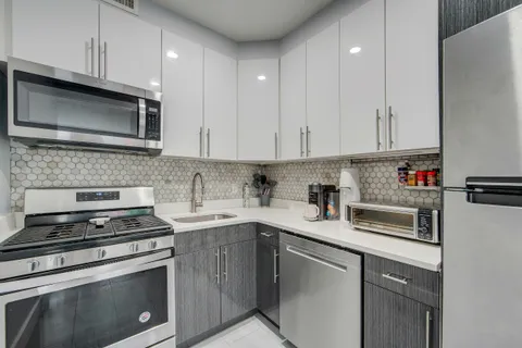 a kitchen with cabinets stainless steel appliances and sink